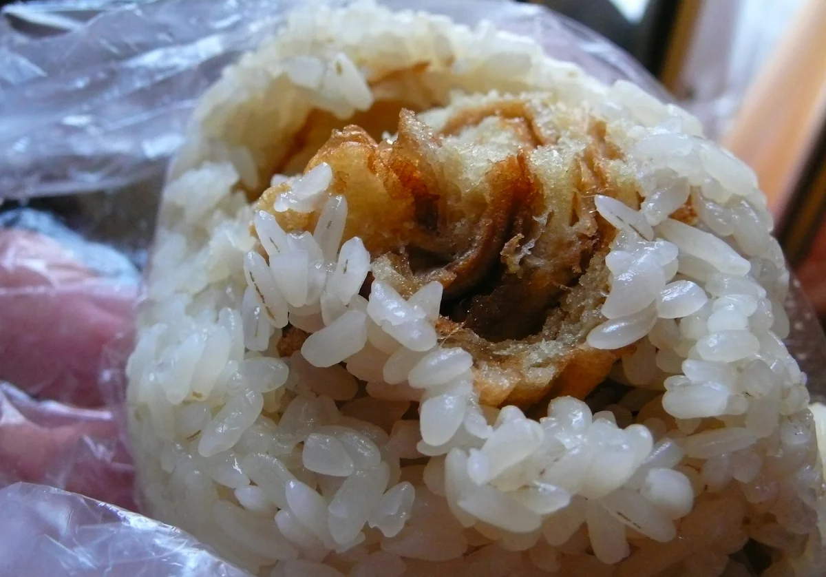 Cut cifan tuan showing sticky rice wrapped around breakfast fillings