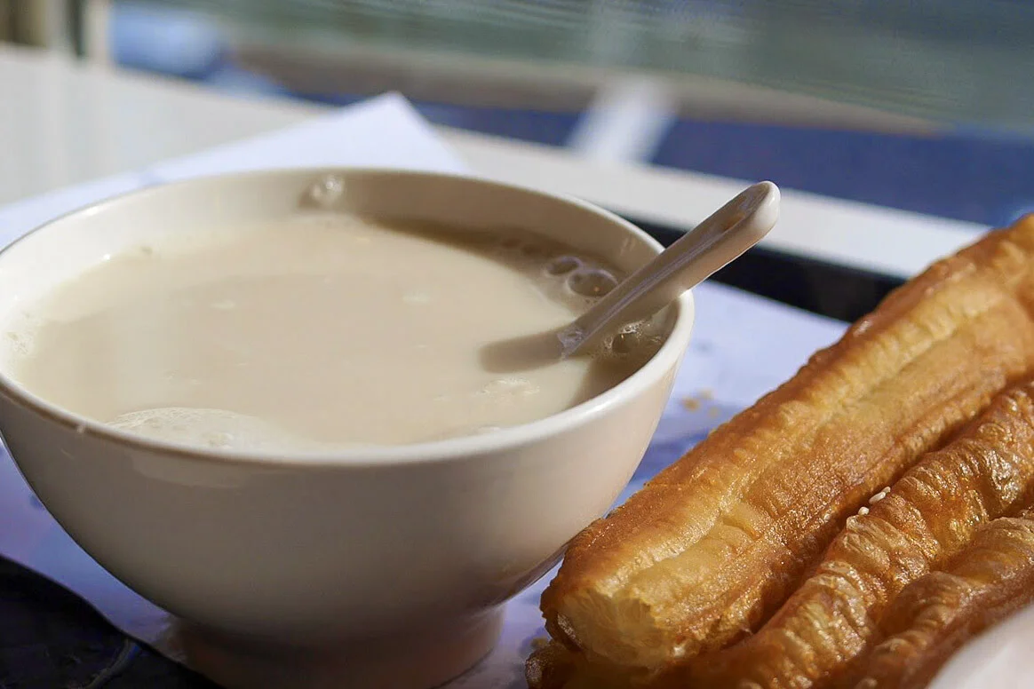 Plain soy milk served with golden youtiao fried dough for breakfast