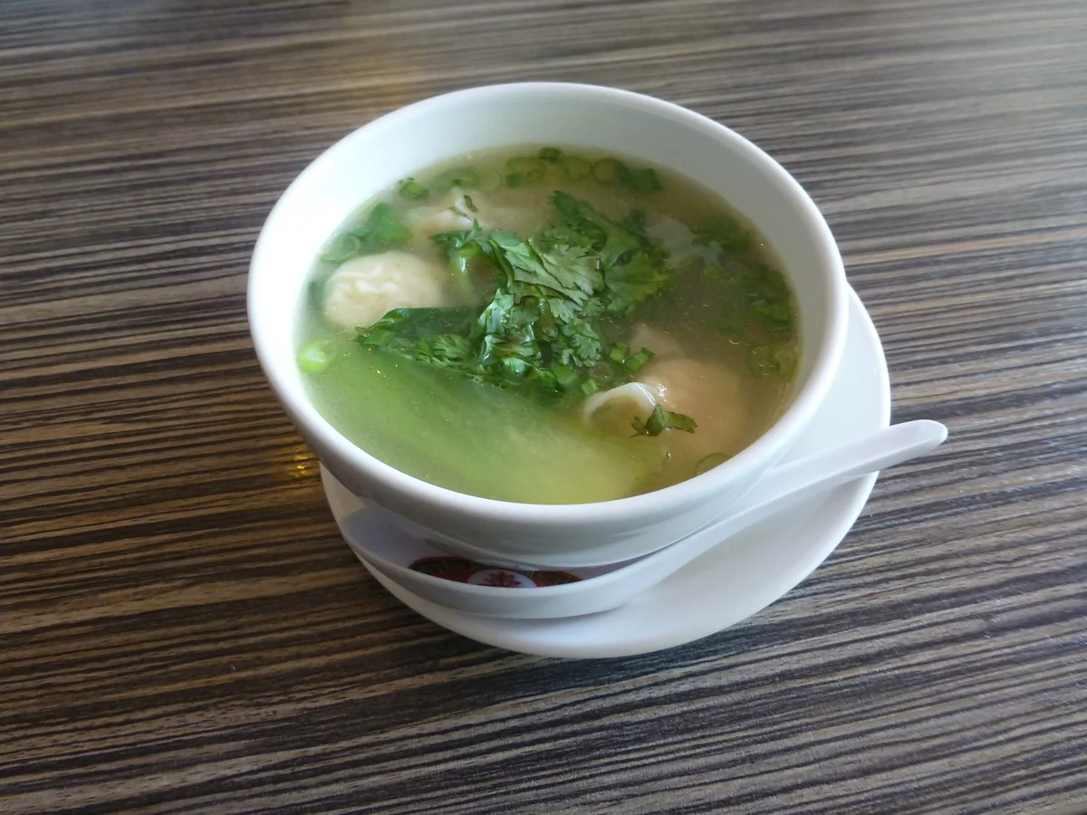 Bowl of wonton soup with soft wrappers and clear broth