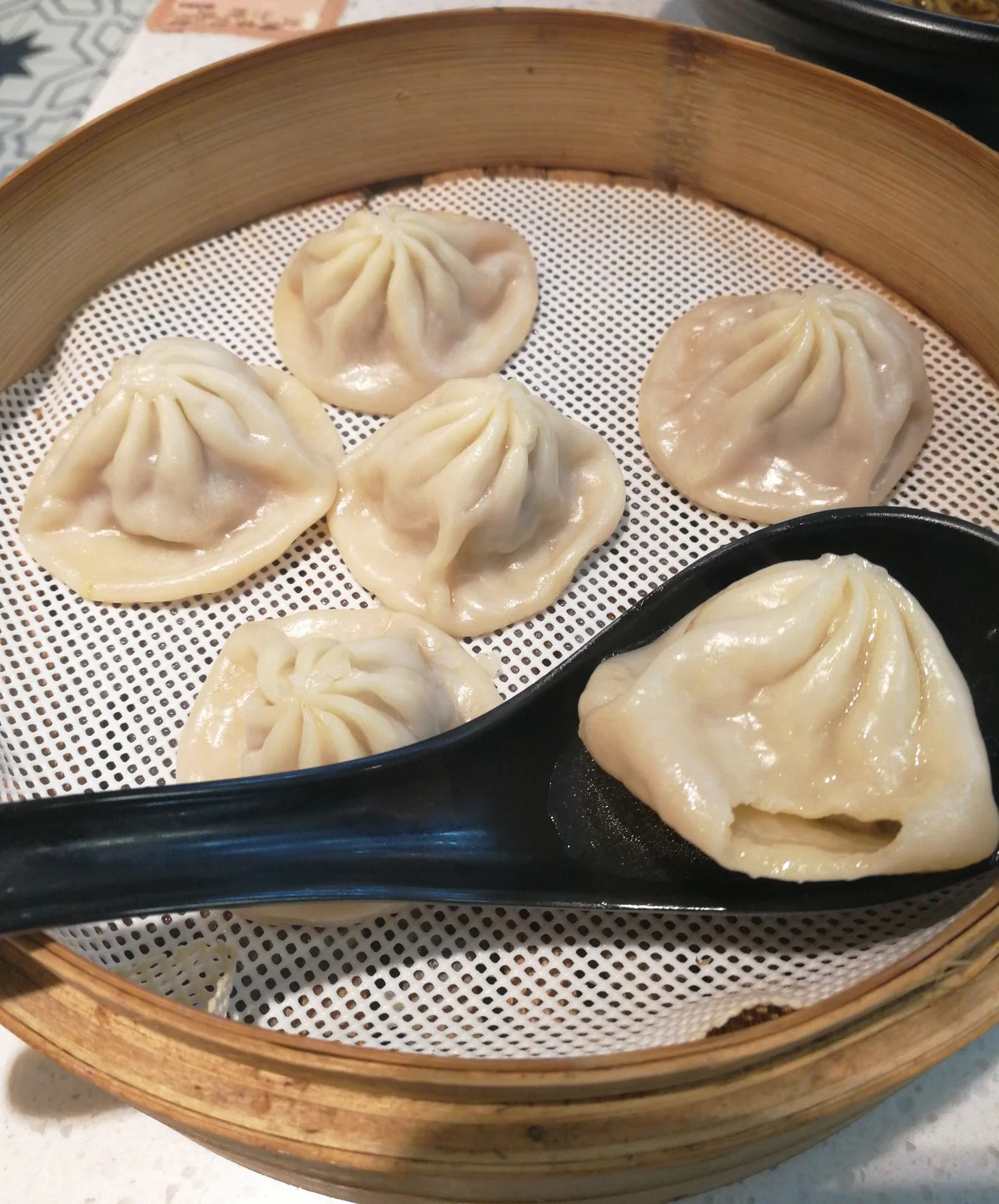 Tall bamboo steamer of Shanghai xiaolongbao soup dumplings