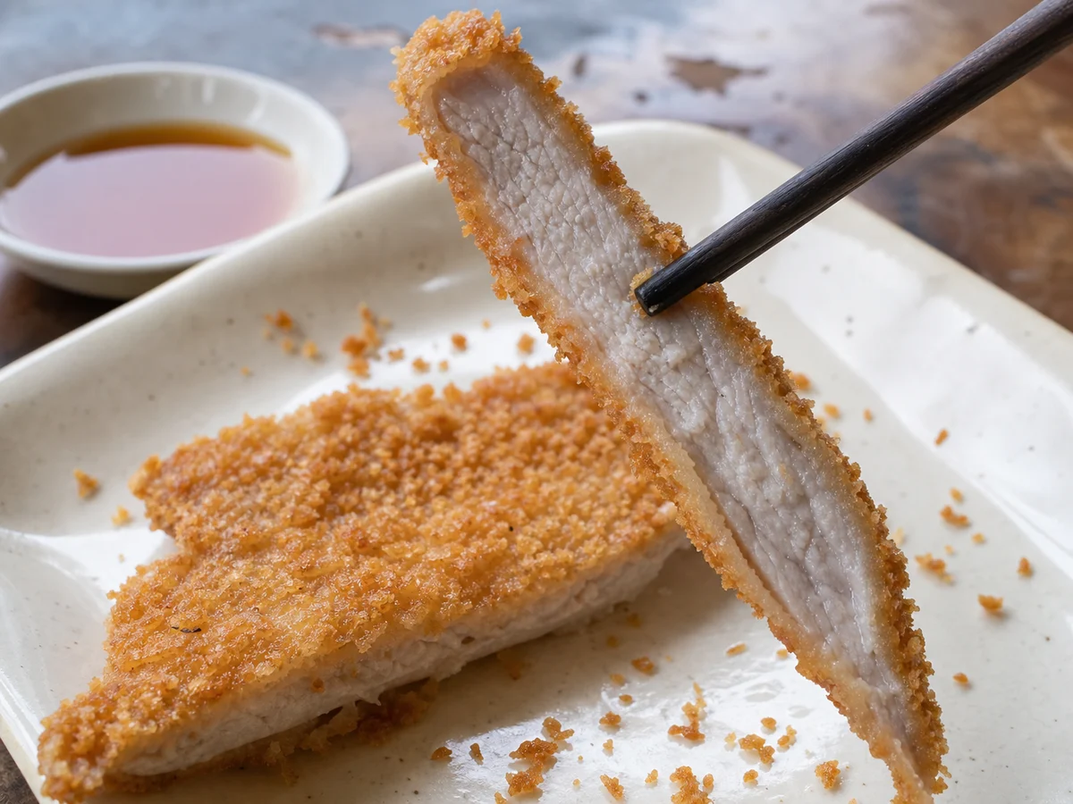 Close view of the crisp crumb and tender center of Shanghai fried pork chop