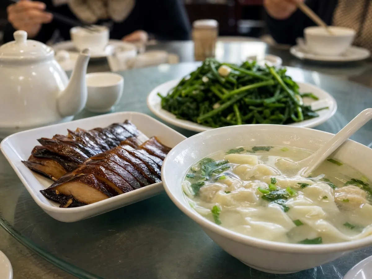Shanghai smoked fish served with clear wonton soup and leafy greens on a shared restaurant table