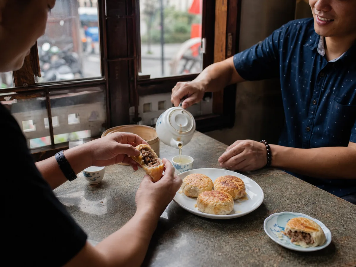 Friends sharing Shanghai fresh meat mooncakes and tea