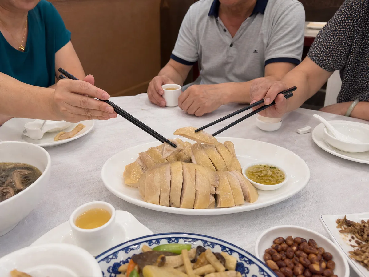 Friends sharing Shanghai sliced cold chicken at a restaurant table